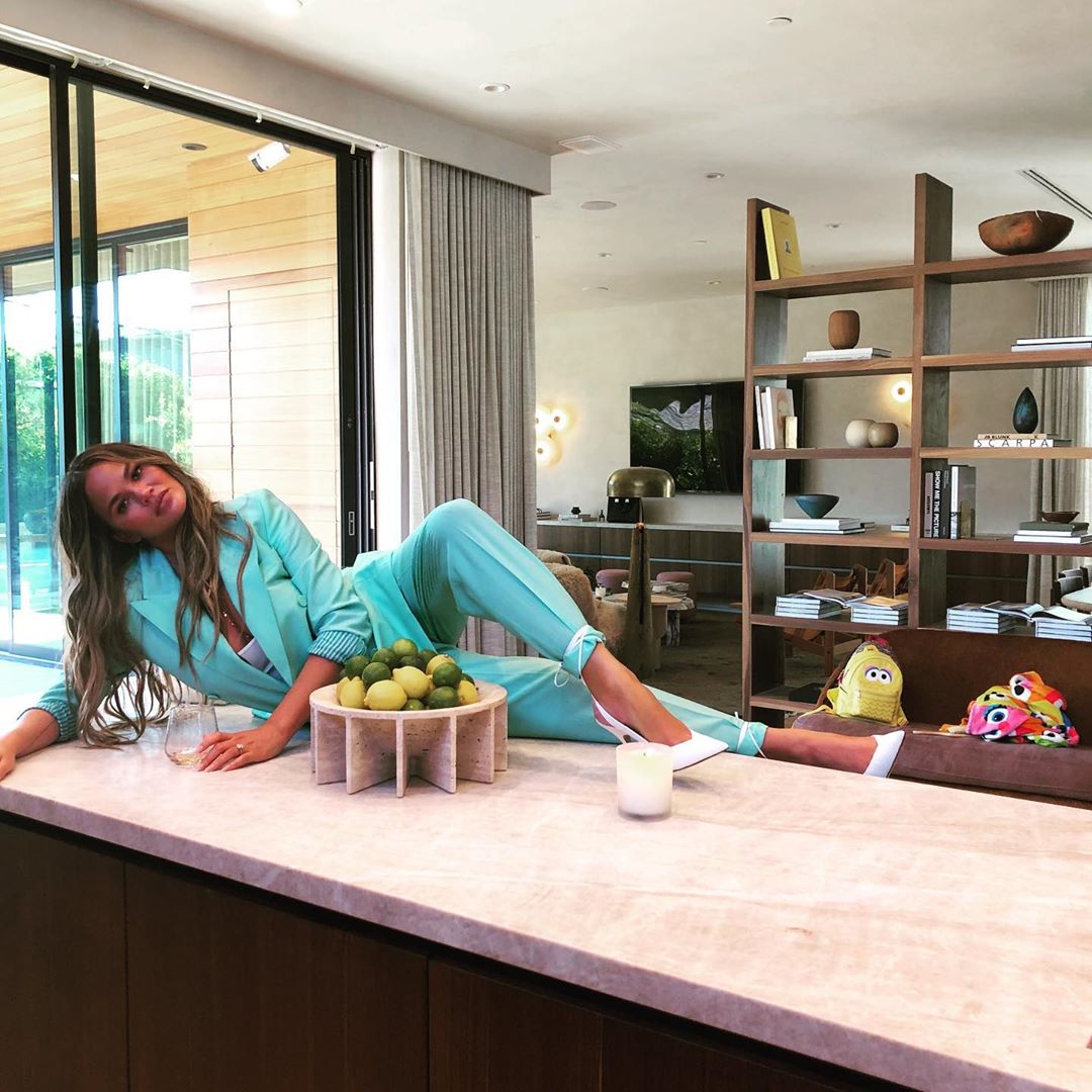 Chrissy Teigen Wearing Ocean Blue Pant Suit And White Heelswhat Stars Own What Stars Own